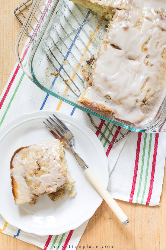 Make this easy cinnamon roll cake recipe for breakfast or brunch. It uses basic pantry ingredients and is ready to eat in under an hour! cinnamon roll cake with piece on plate