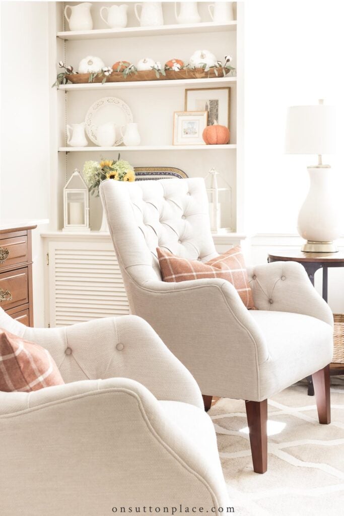 two tufted chairs in living room with fall decor