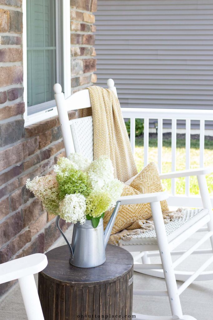 fall porch decor white rocker throw blanket pillow dried hydrangeas wood garden stool