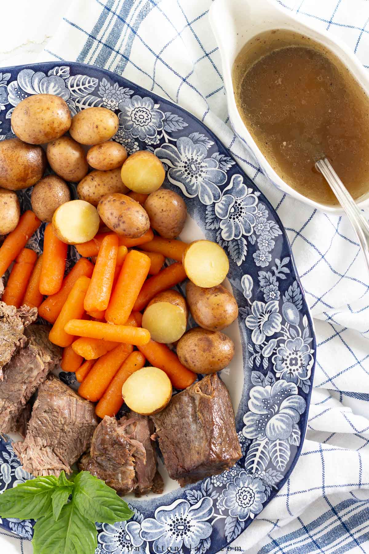 classic pot roast on blue platter with au jus