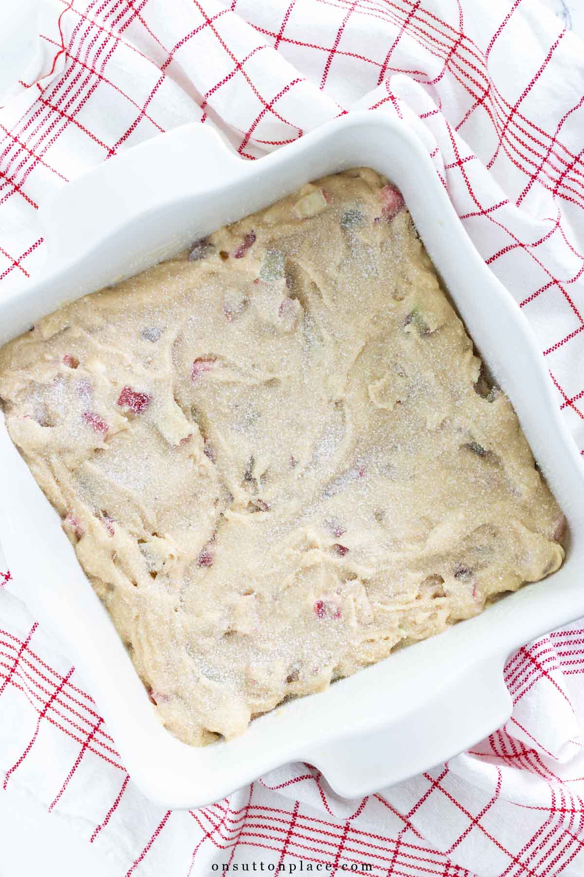 rhubarb cake recipe batter in 8x8 baking dish