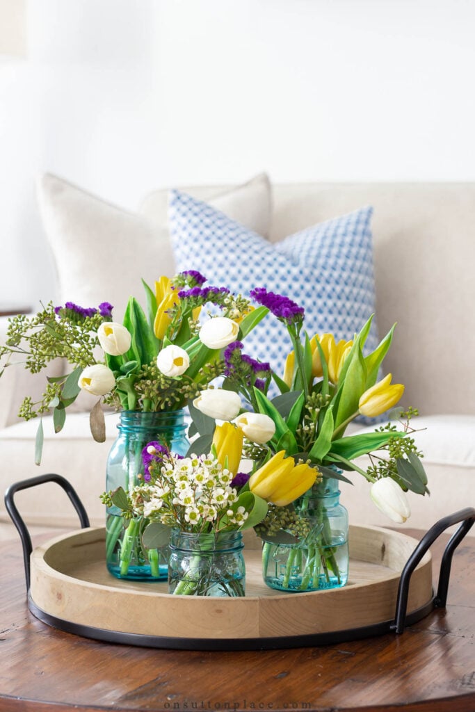 vintage blue mason jars with flowers on round tray decorating with collections