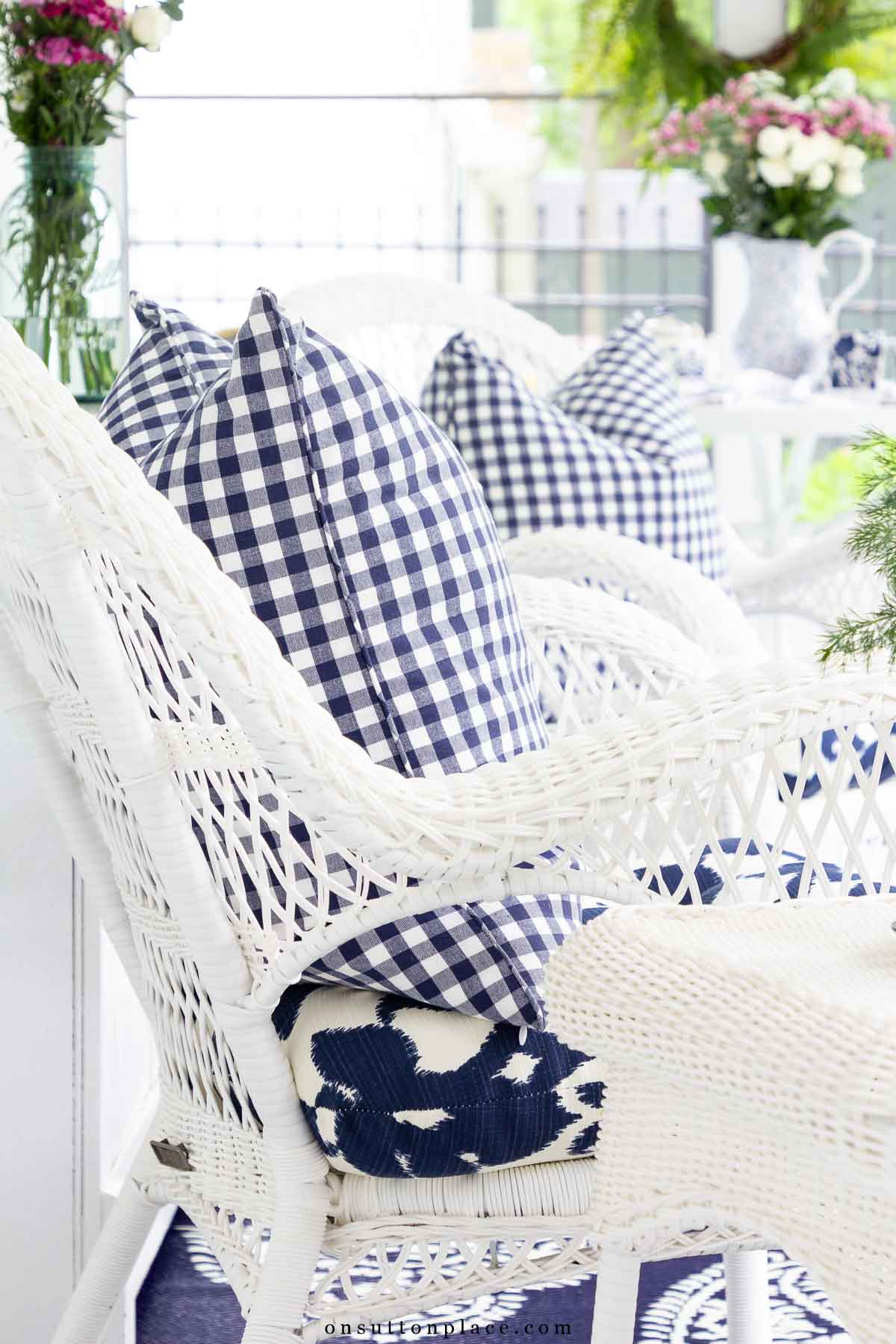 blue and white porch pillows and outdoor seating on a screened porch