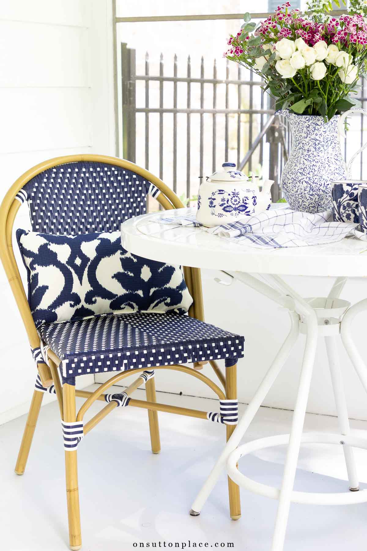 small screened in back porch with round table and bistro chairs