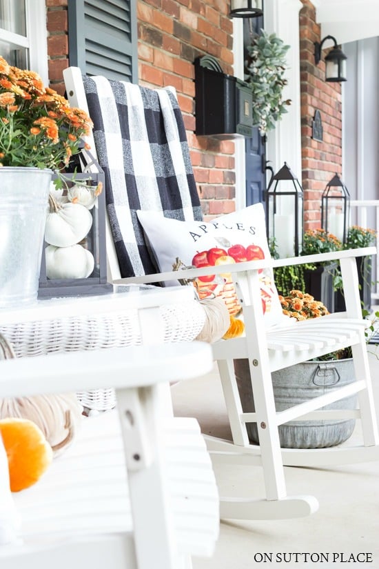 rockers on front porch decorated for fall