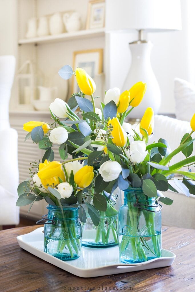 group of mason jars on tray with tulips 2022