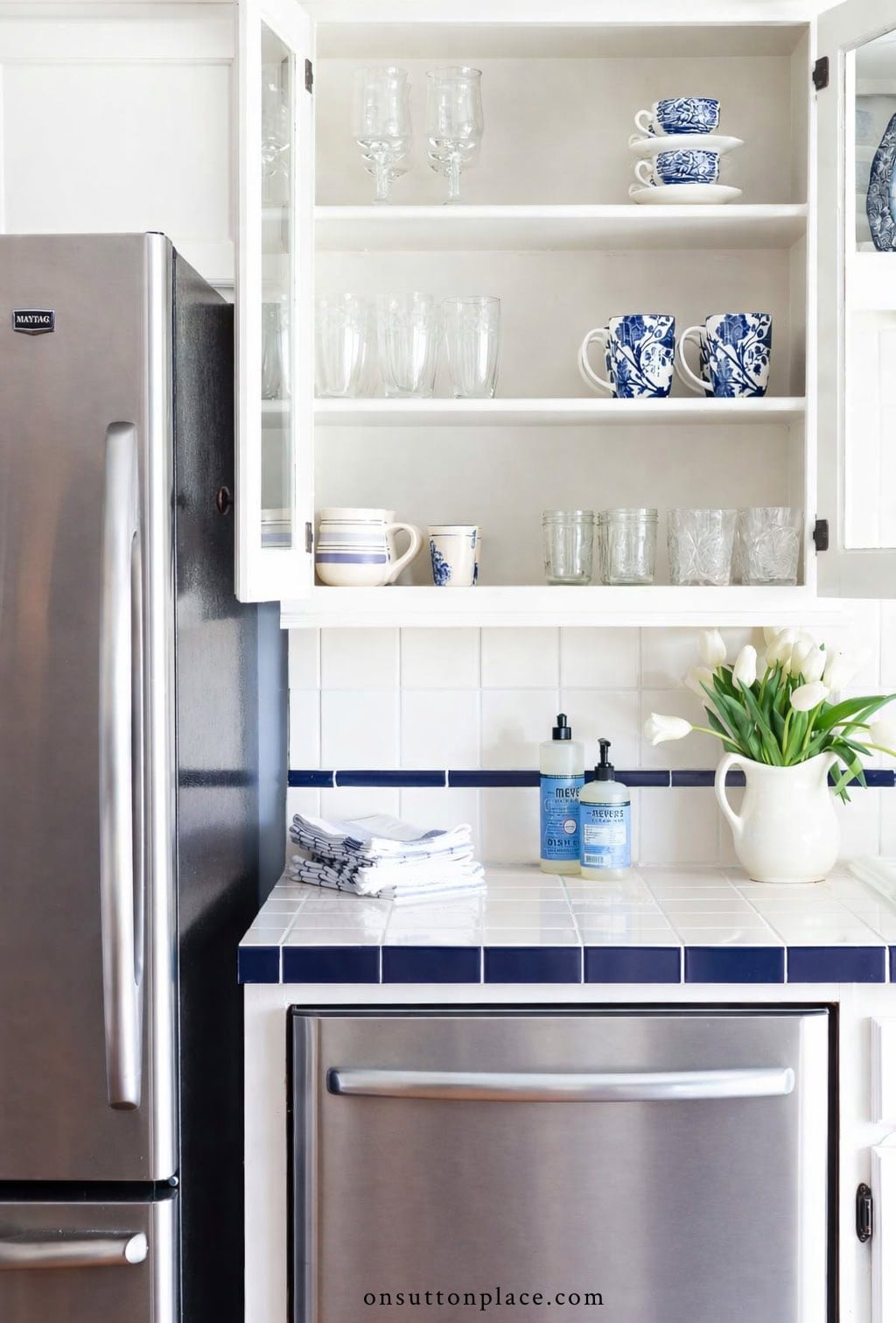 kitchen cabinet organization ideas glassware and cups lined up in kitchen cupboard