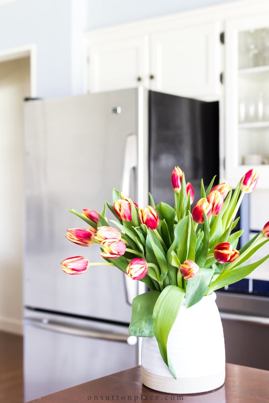 red tulips in kitchen in front of refrigerator