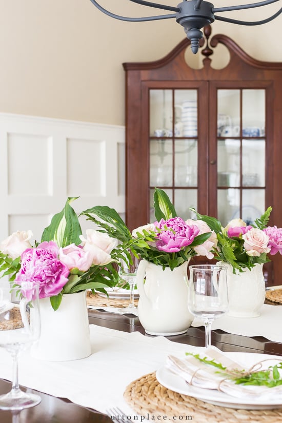 These table setting tips for summer meals will help you keep things simple, neutral, and natural. Ways to entertain in the summer months without the stress! three pitchers on dining room table