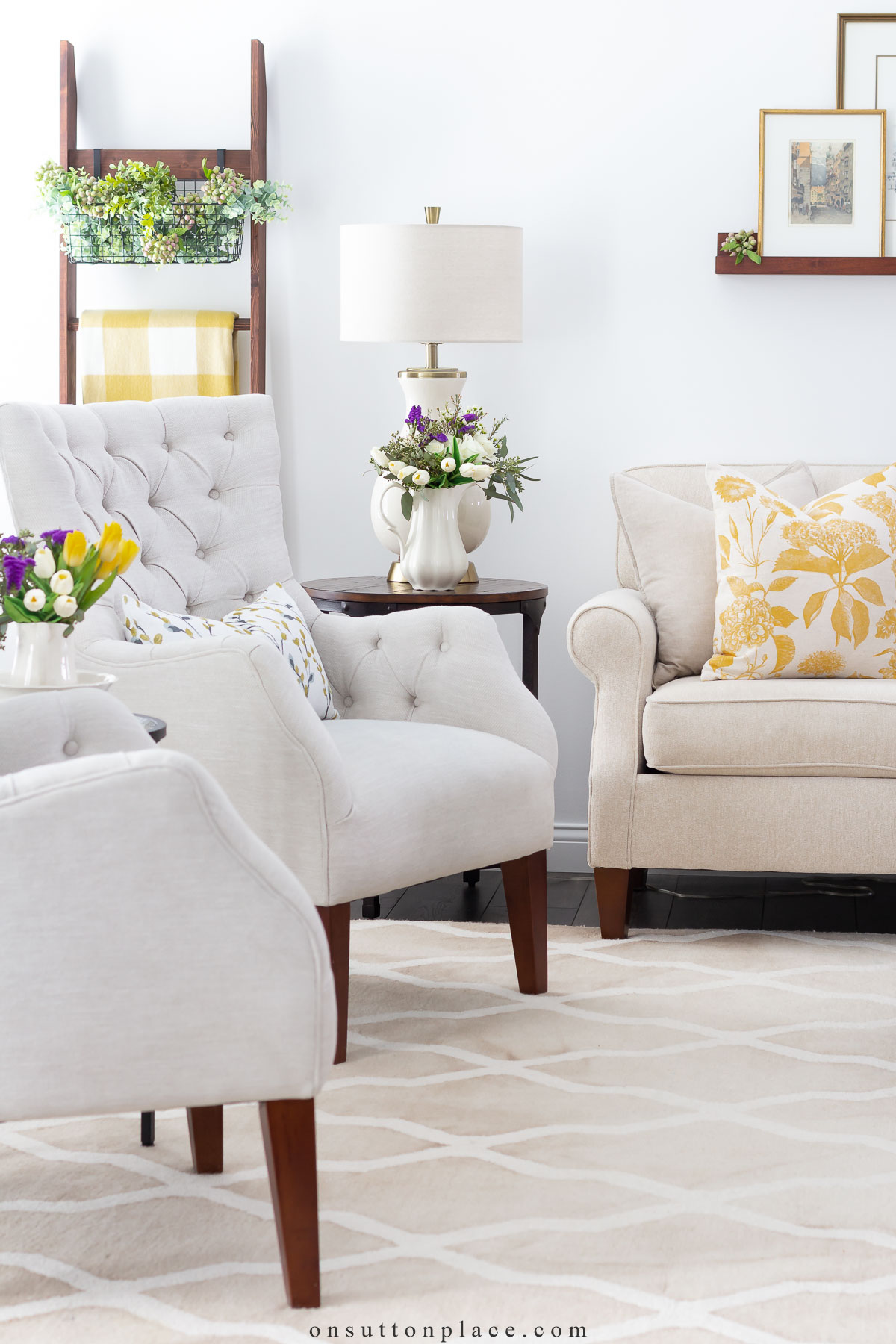 neutral living pair of tufted chairs sofa with yellow pillows