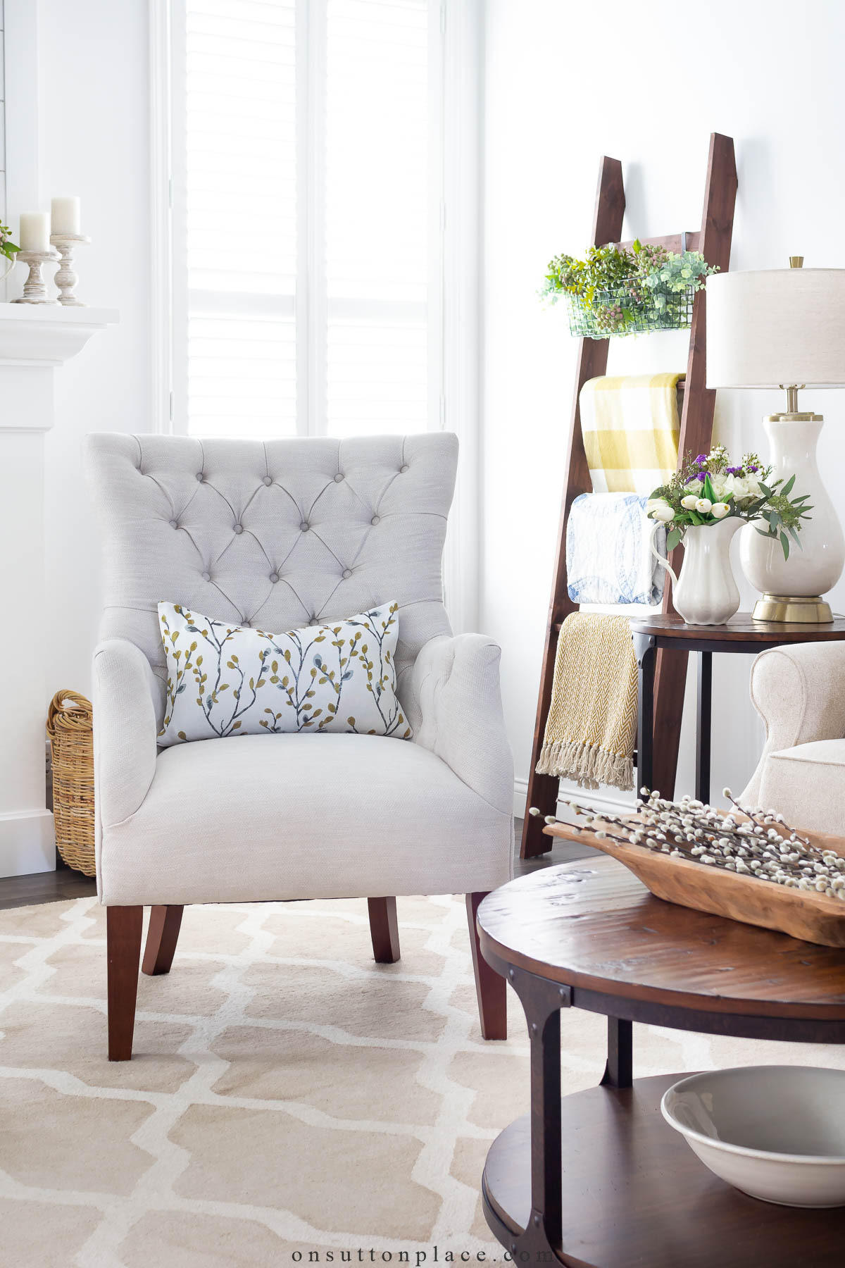 neutral tufted chair in living room with spring accents