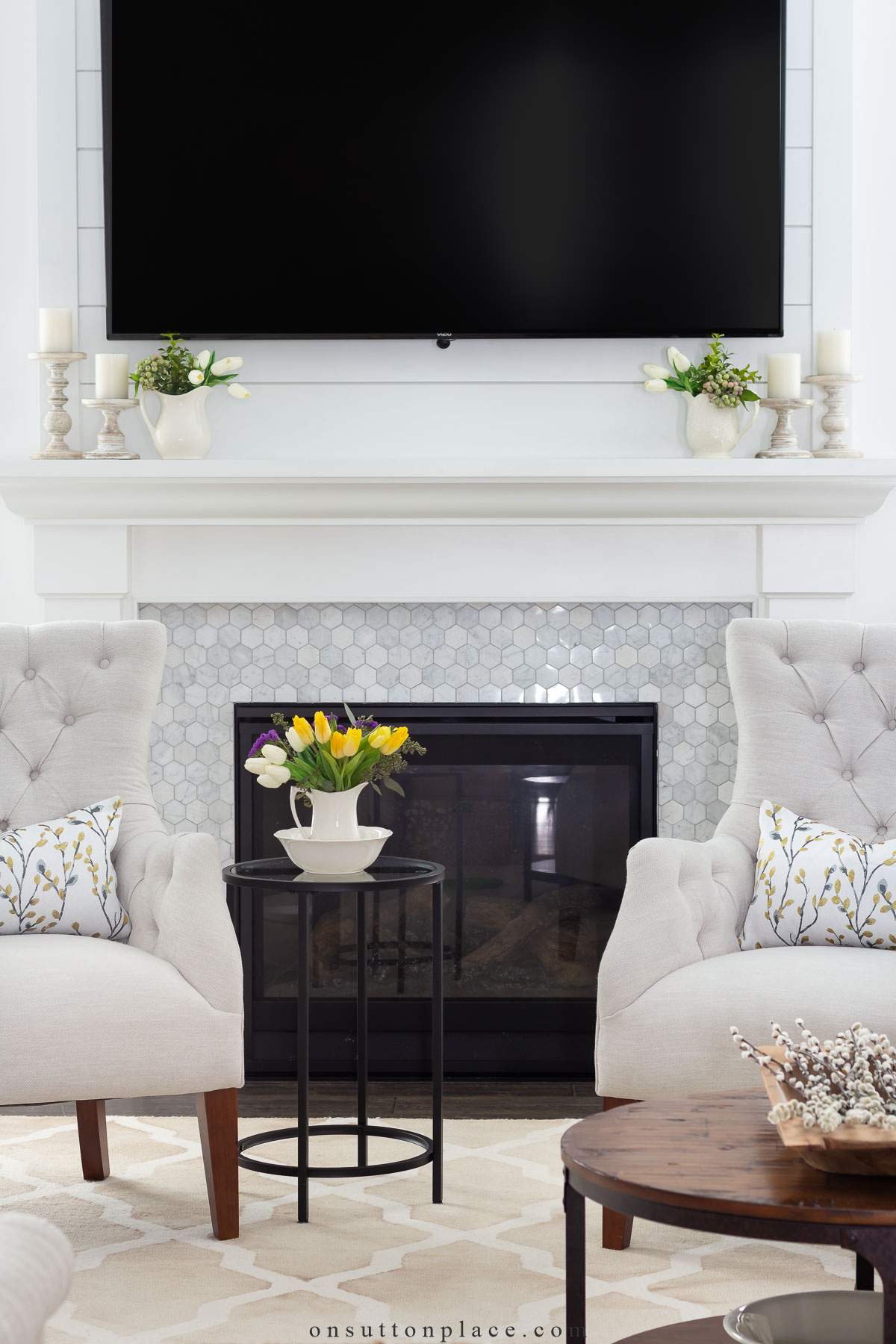 tv over fireplace in neutral living room with spring decor
