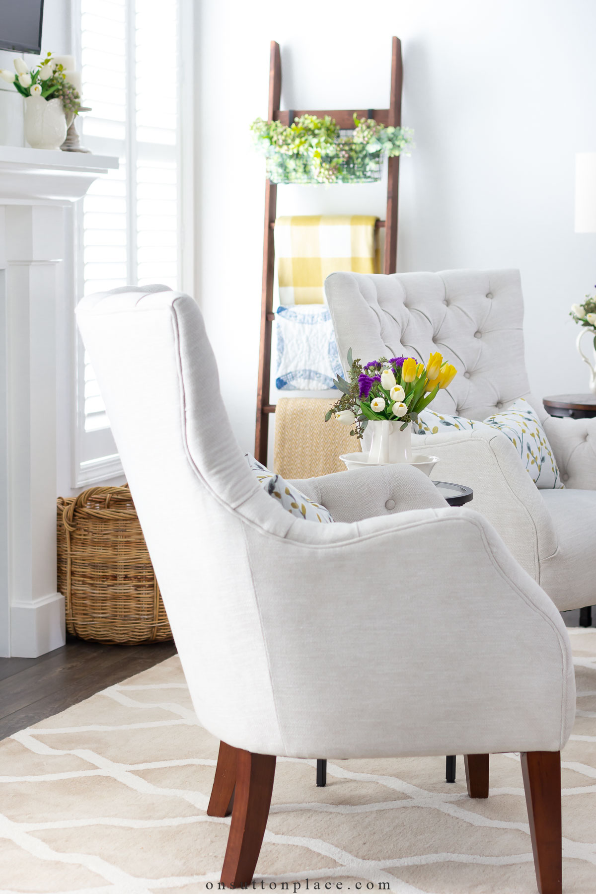 two chairs in neutral living room blanket ladder with yellow throw blankets