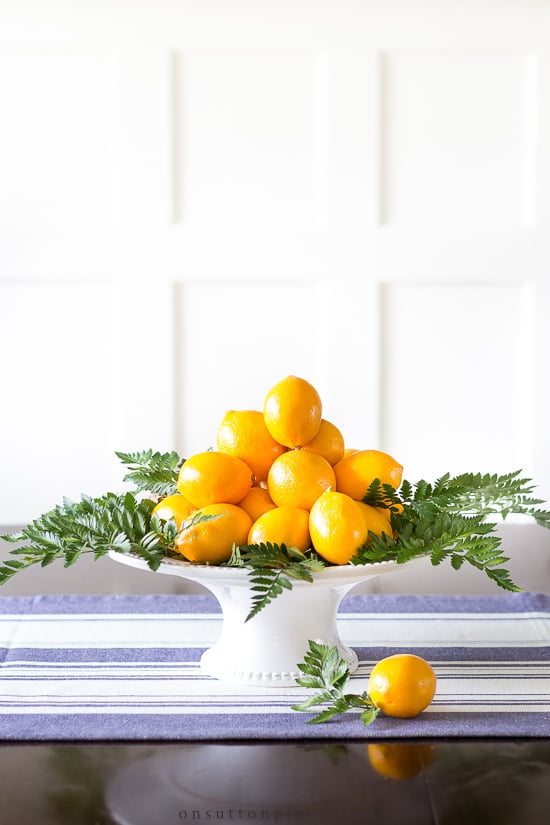 Make this fresh and beautiful meyer lemon centerpiece with items found at the grocery store, and in way under 20 minutes! #centerpiece #centerpieceidea #fruitcenterpiece #meyerlemon meyer lemon centerpiece on table