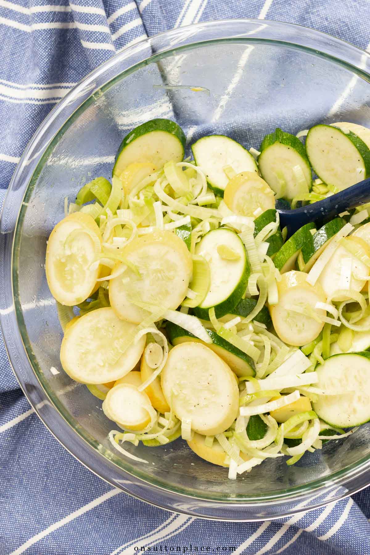 slices of green and yellow zucchini with leeks in bowl