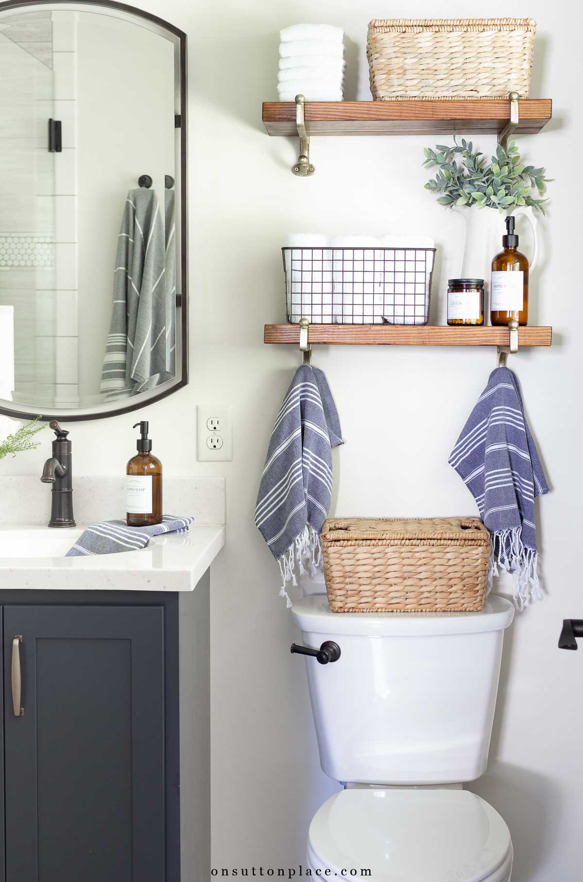small primary bathroom remodel neutral walls navy blue vanity open shelves for storage