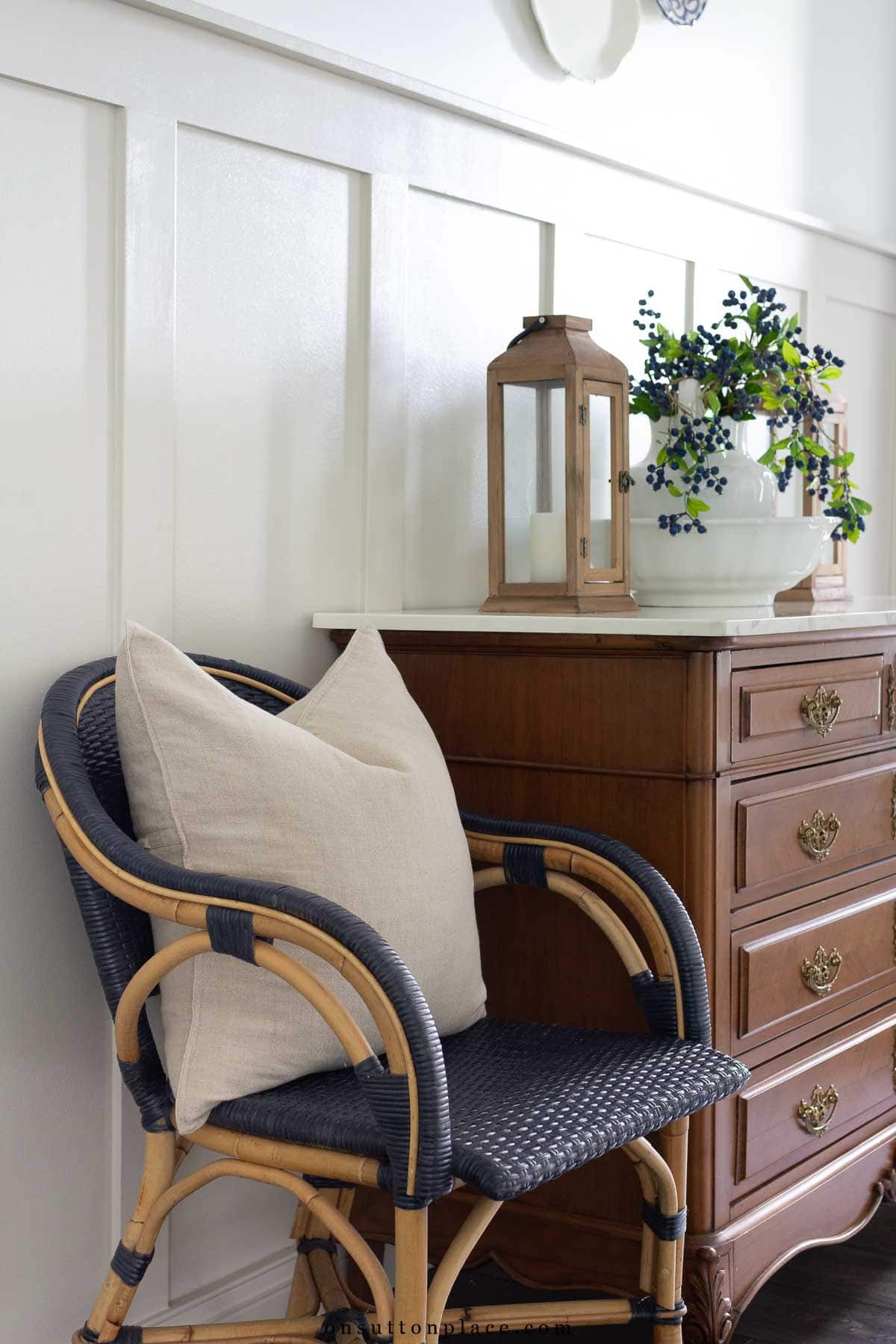 linen pillow cover on wicker armchair in entry