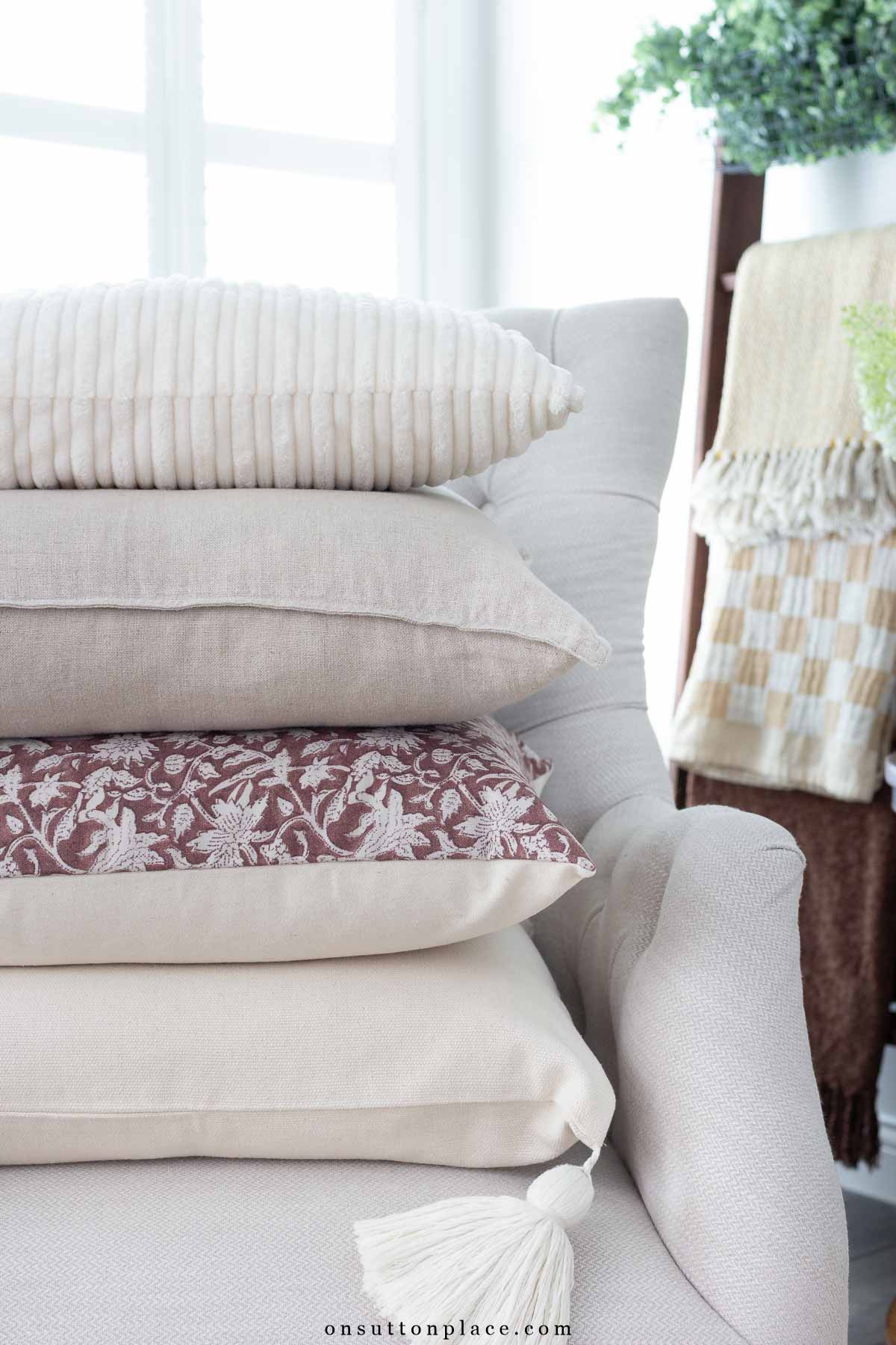 stack of neutral pillows on chair