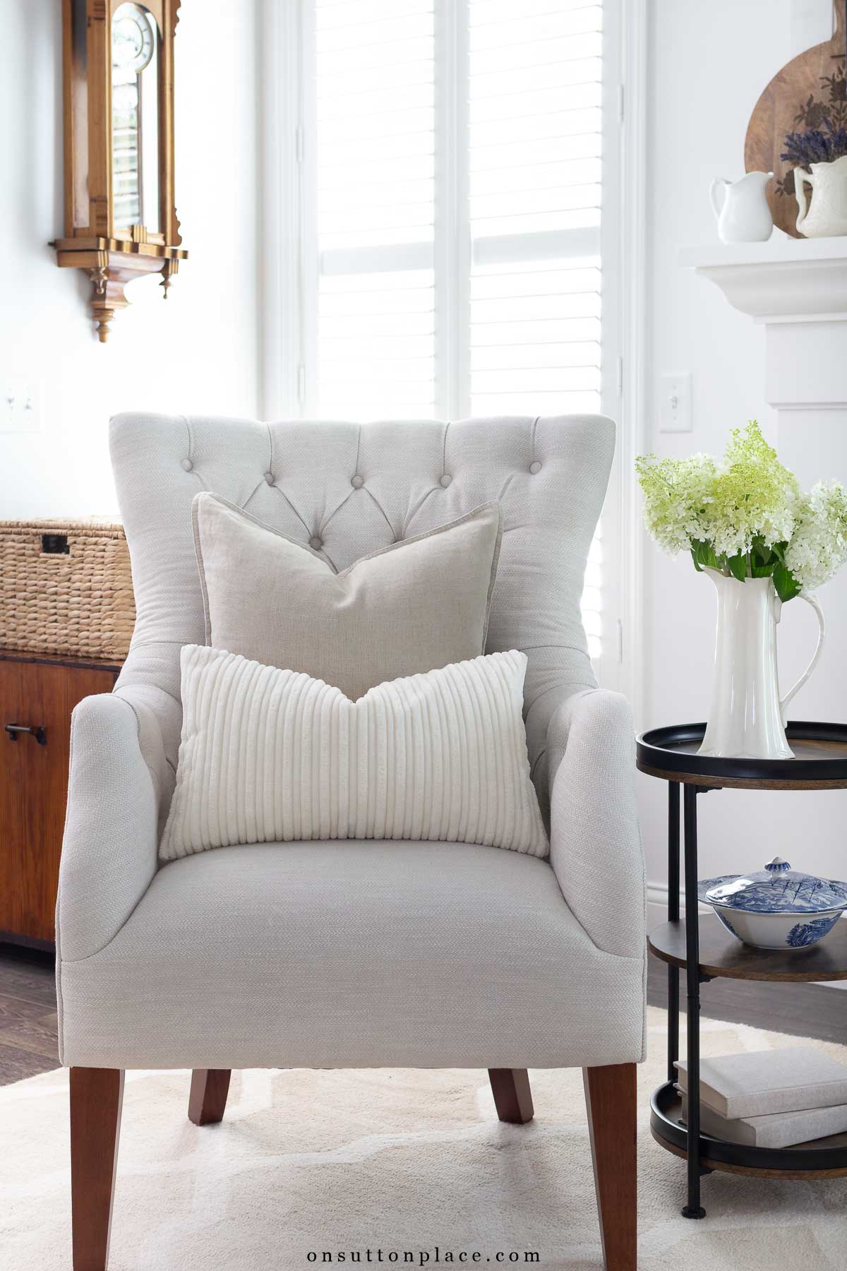 two neutral pillows arranged on tufted chair