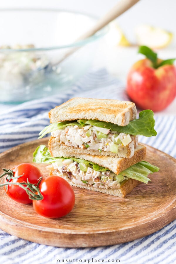 Make this chicken salad with apples for an easy lunch, or a casual dinner. Pile the chicken salad on thick toast for a filling & crunchy sandwich. stacked toasted sandwich on round wood board with tomatoes