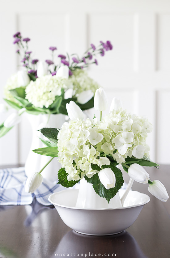 Do you know how to decorate with different kinds of flowers? The answer is broken down into specific kinds of flowers, vessels, & adding faux flowers. pitchers of different kinds of flowers on table