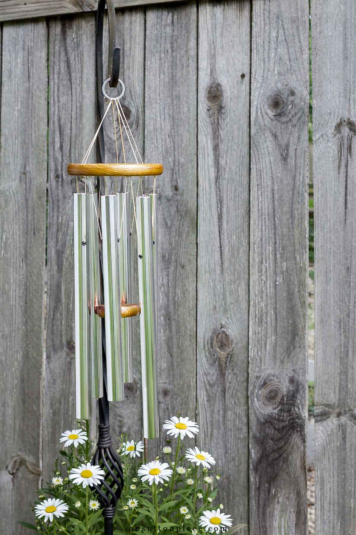 windchimes on shepherd hook with shasta daisies