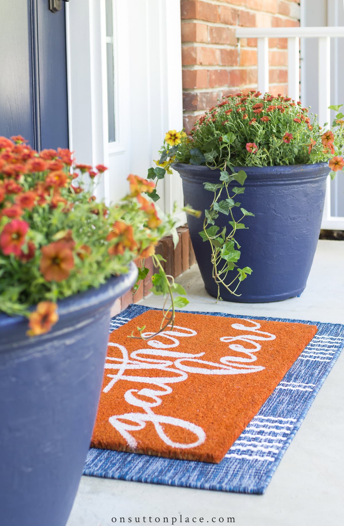 layered fall doormats with blue planters