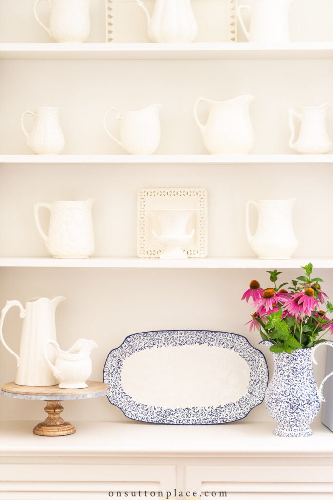 pitchers and a plate on built in shelves