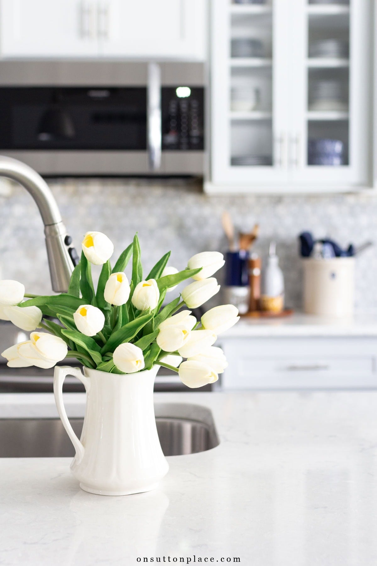 uncluttered kitchen counter with pitcher of tulips homemaking and simple living