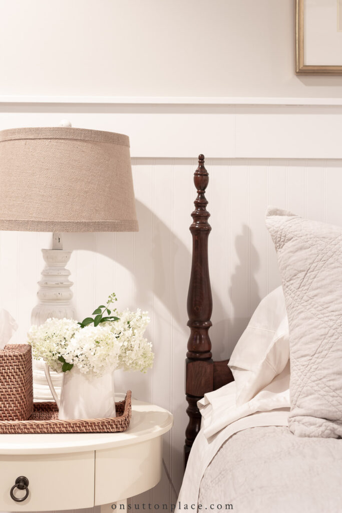 bedside table and bed in front of beadboardwall