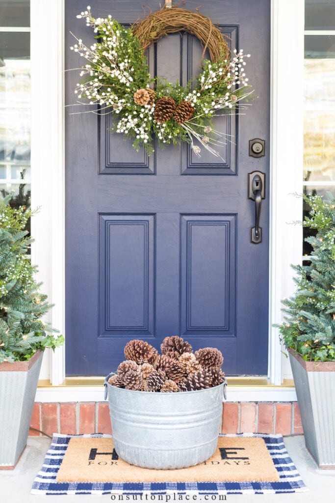 grapevine wreath with white berries on blue front door