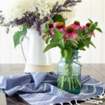 garden flowers arranged in a farmhouse pitcher and blue mason jar