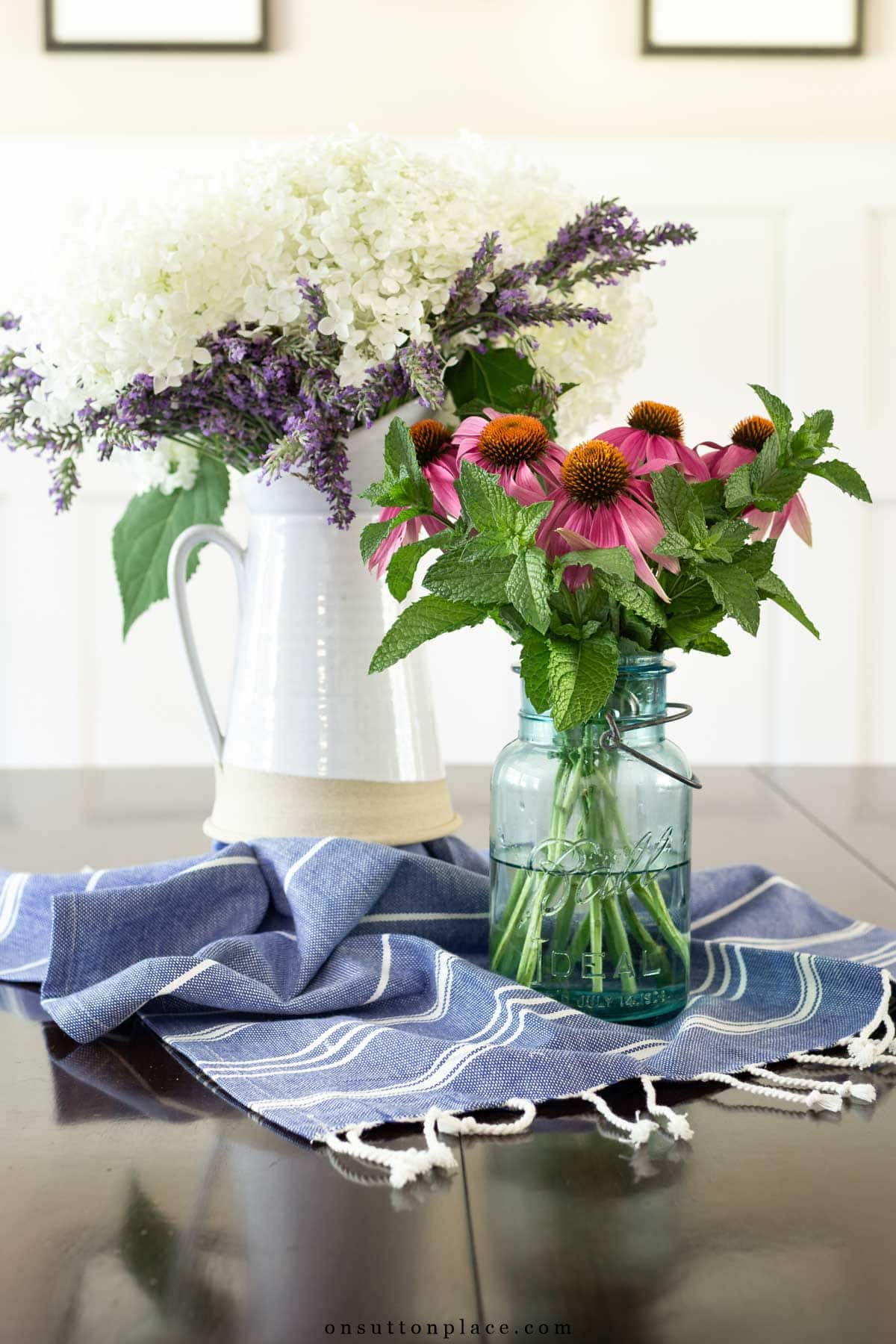 garden flowers arranged in a farmhouse pitcher and blue mason jar