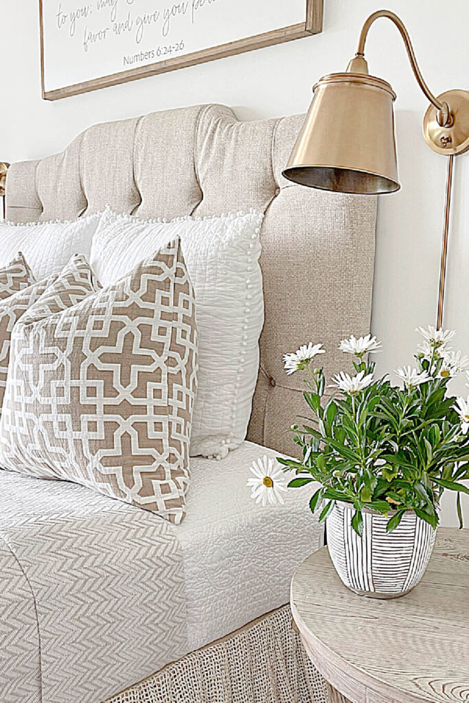 neutral upholstered bed with light and side table