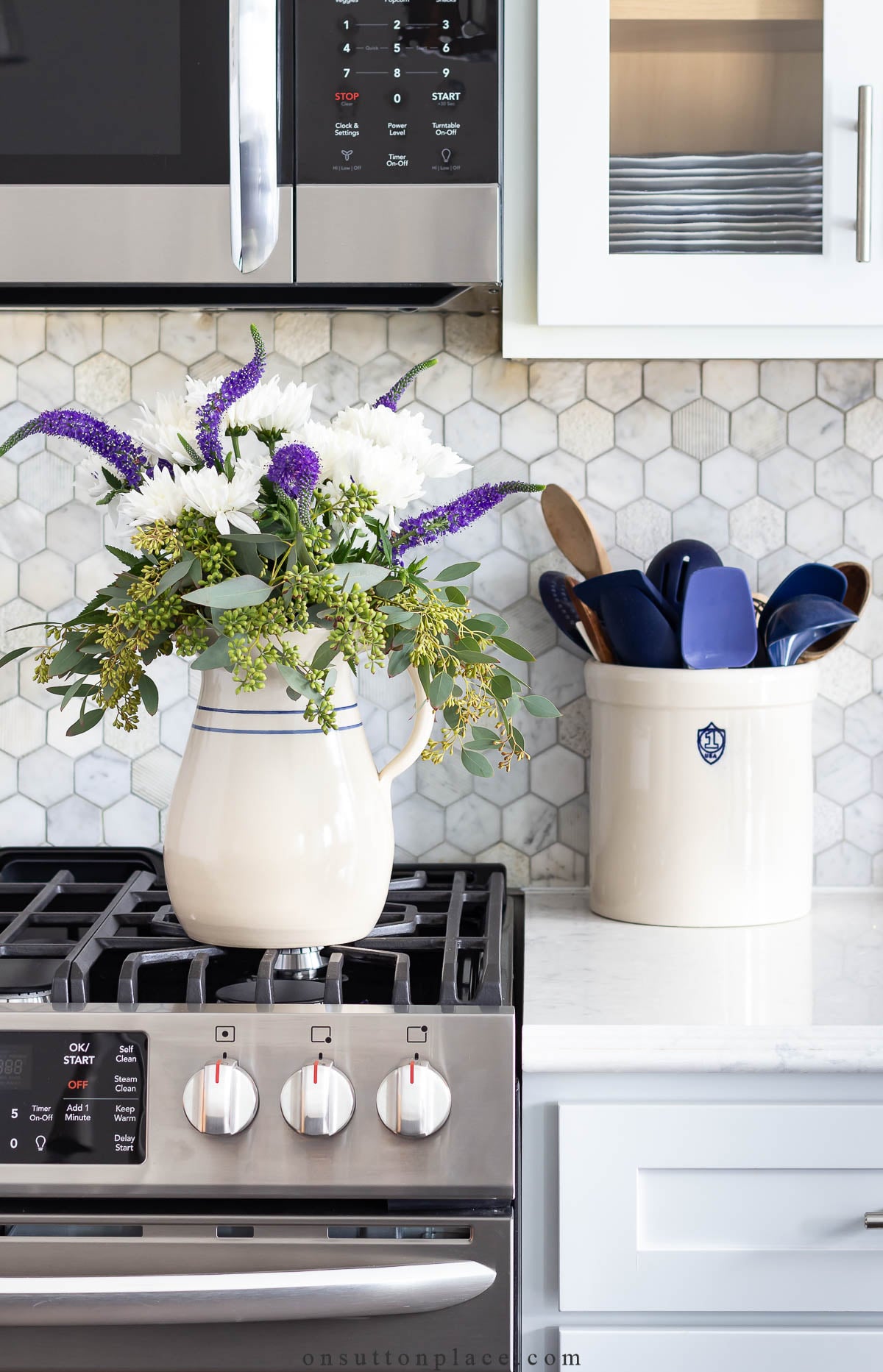farmhouse pitcher of flowers on gas range in kitchen 2023