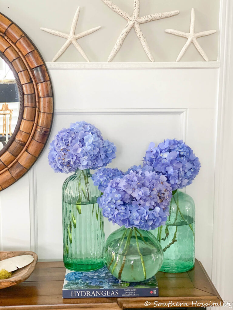 vases of blue hydrangeas on entry table southern hospitality