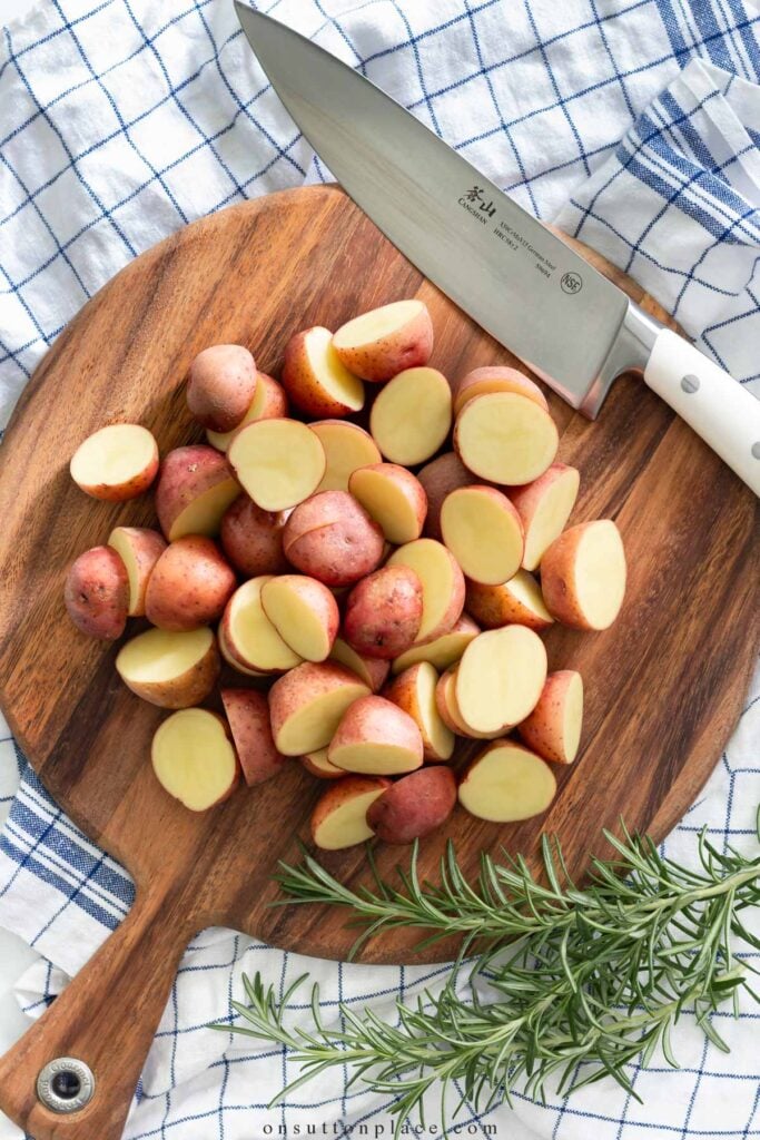 chopped red potatoes on round wood board