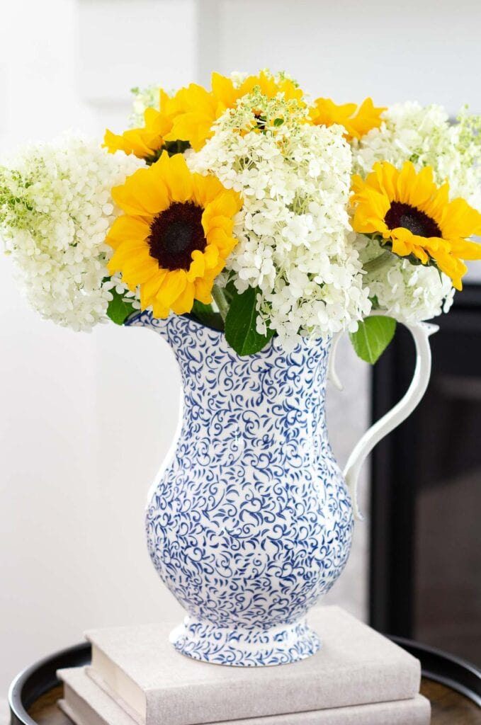 sunflower and hydrangea arrangement in blue and white pitcher