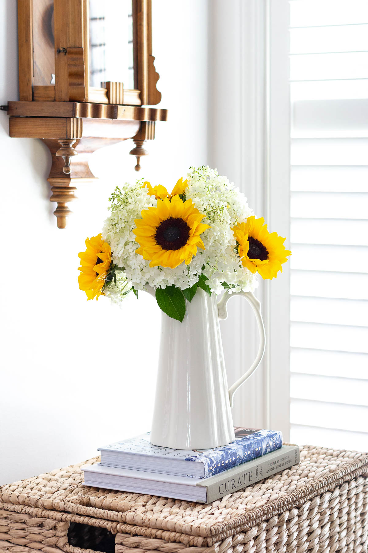 sunflower and hydrangea arrangement on 2 books