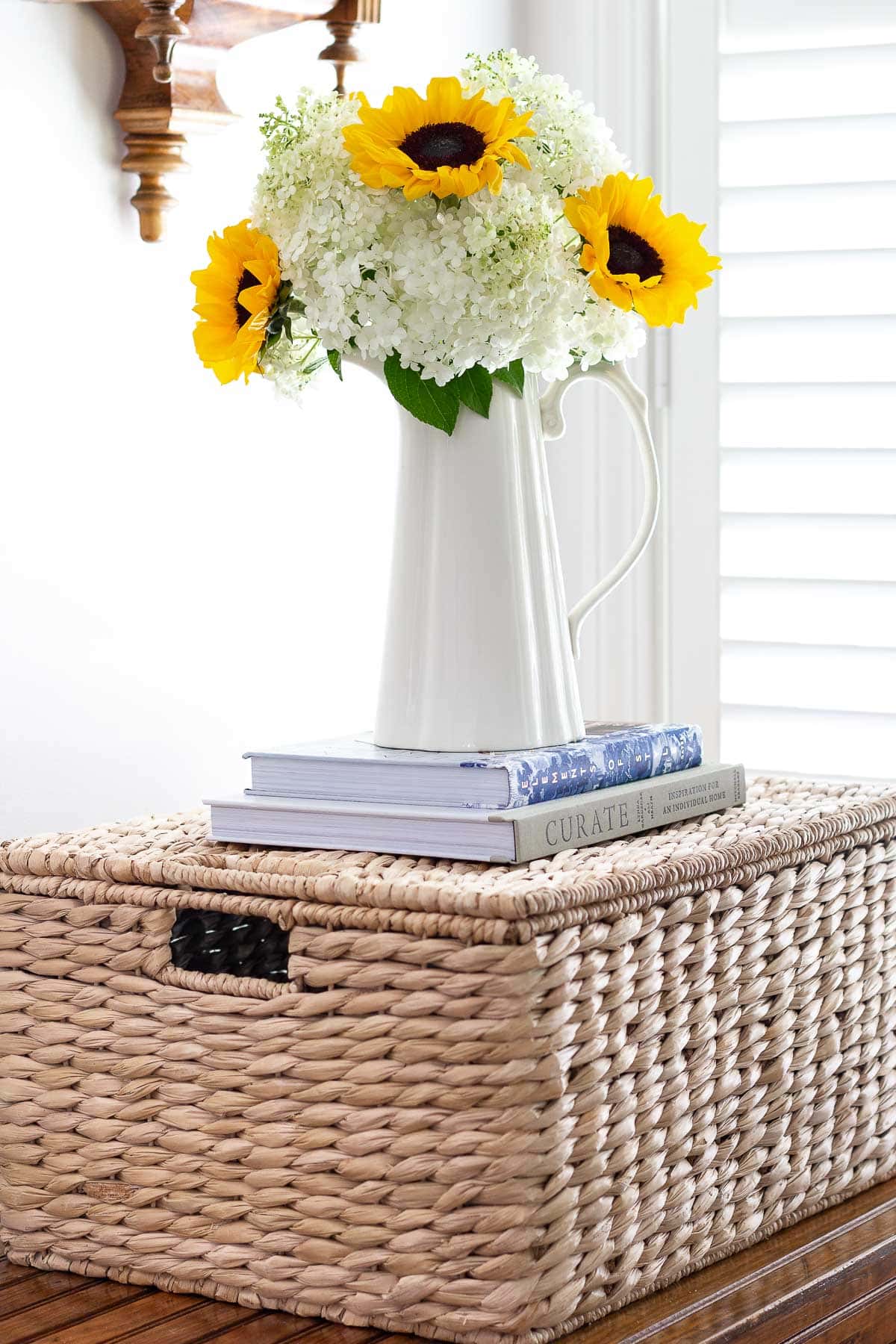 sunflower and hydrangea arrangement on basket with books