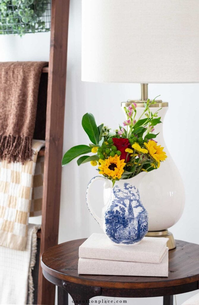 fall vignette idea flowers in fall colors in pitcher with books stacked underneath