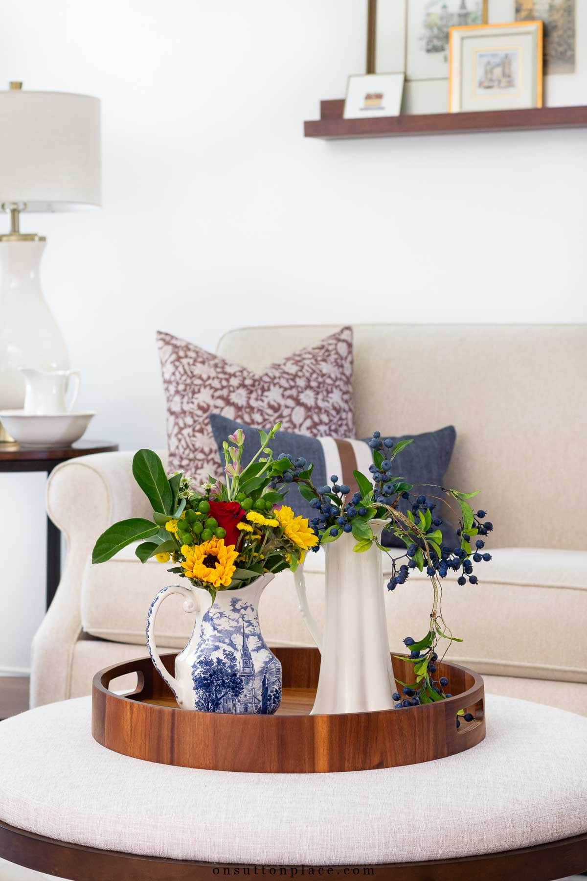 ottoman with round tray and two pitchers filled with flowers