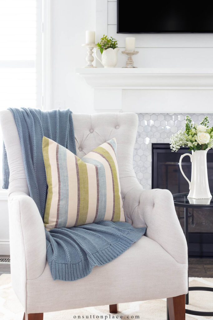 tufted chair with blue throw blanket and striped pillow tips for a simpler life