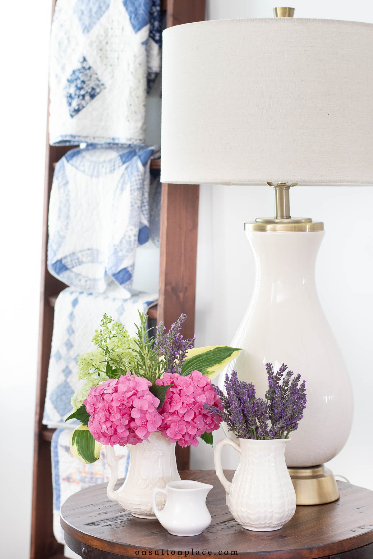 collection of pitchers with flowers on side table