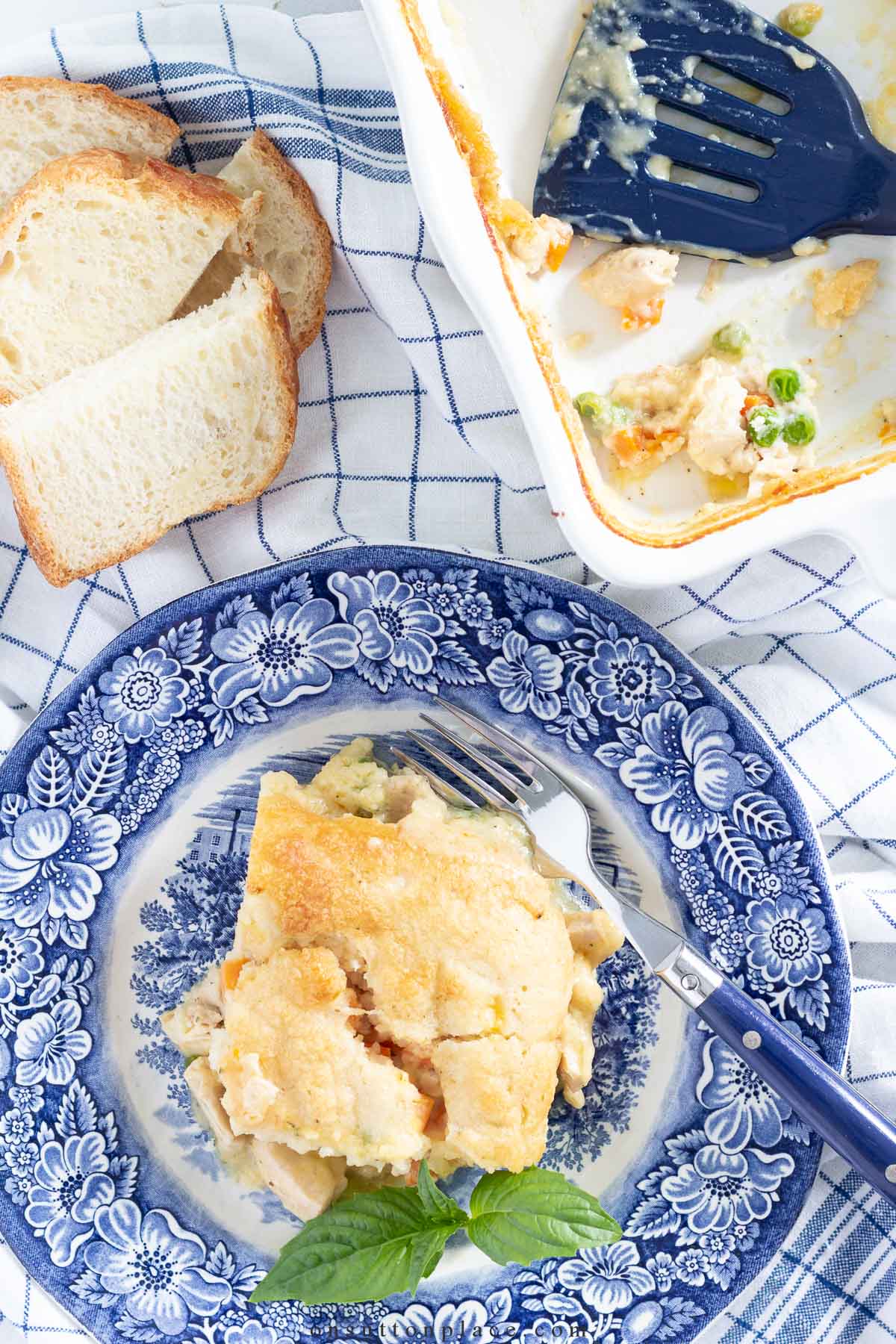 small batch chicken cobbler on blue plate with a side of sliced bread