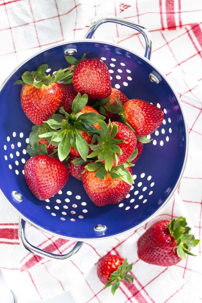 fresh strawberries in blue colander