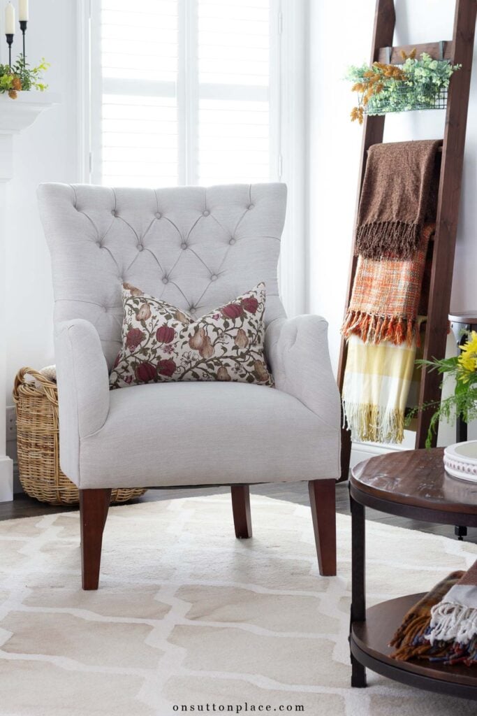 tufted chair with fall pillow blanket ladder