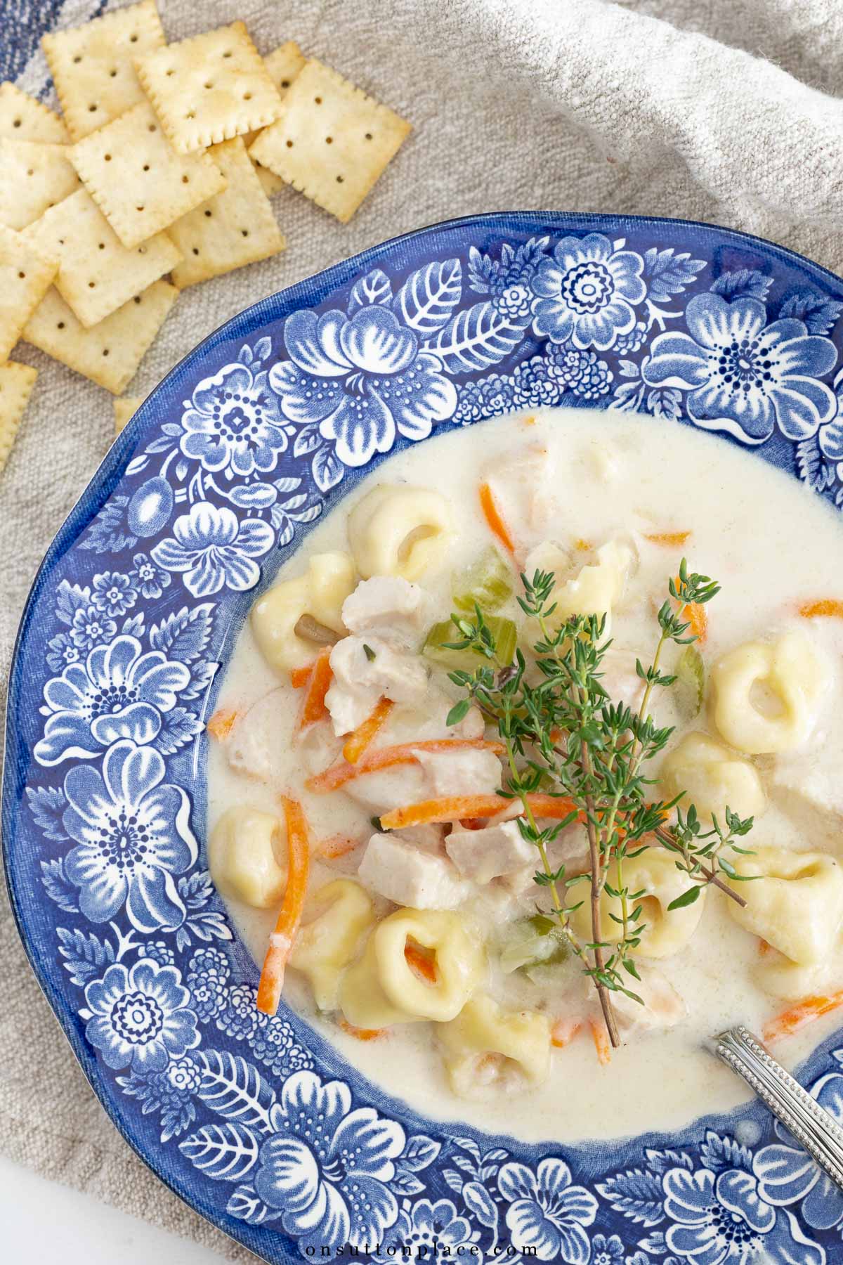 bowl of creamy chicken tortellini soup with crackers