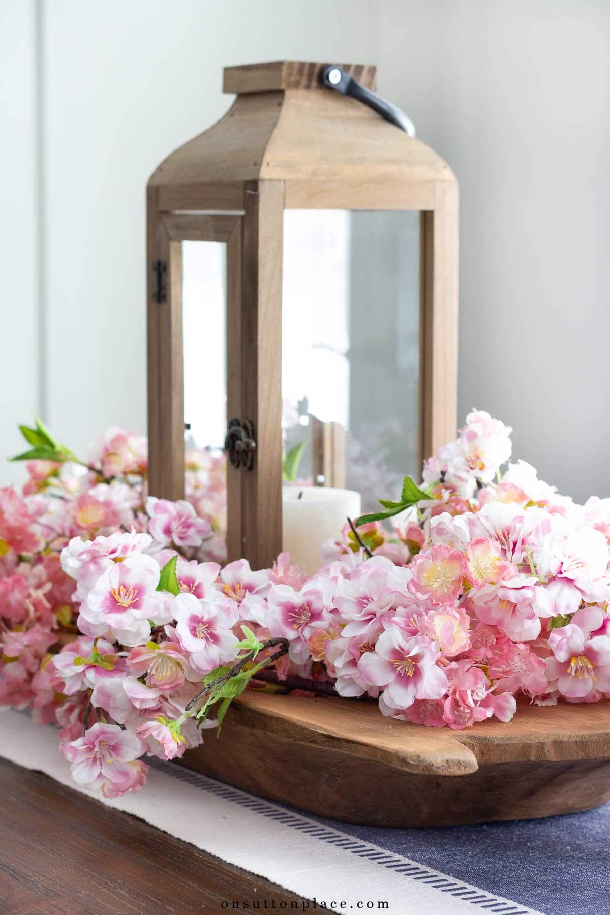 dough bowl with wood lantern and faux cherry blossoms centerpiece