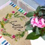 coir doormat layered over colorful striped rug